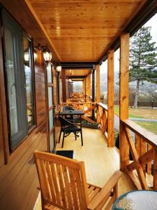 un porche de una cabaña con mesa y sillas en Chateau Ateni Cottages, en Gori