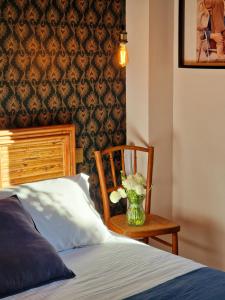 ein Schlafzimmer mit einer Vase aus Blumen und einem Stuhl in der Unterkunft Les Lauriers in Saint-Tropez