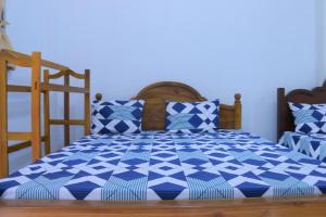 a blue and white bed with blue and white pillows at Rochesta Holiday Inn in Badulla