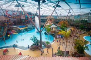 ein großer Indoor-Wasserpark mit Menschen darin in der Unterkunft 2 Bed Stylish Peak District Cottage Barn Near Alton Towers, Polar Bears, Chatsworth House in Waterfall