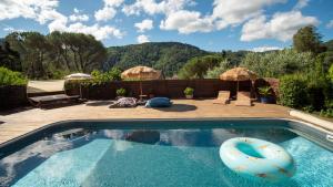a swimming pool with an umbrella and an inflatable at Le Chalet - Les Lodges de Praly in Les Ollières-sur-Eyrieux