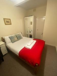 a bedroom with a large bed with a red blanket at The Portsburgh Square Residence in Edinburgh
