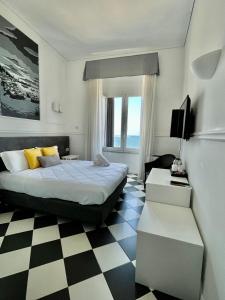 a bedroom with a bed and a checkered floor at Hotel Stabia in Castellammare di Stabia