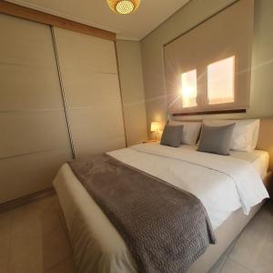 a bedroom with a large white bed with two pillows at Volos Park Apartments in Volos