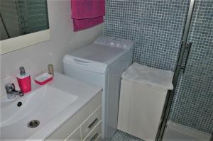 a bathroom with a sink and a washing machine at Studio Ponderosa in Playa de las Americas