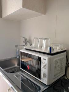 a microwave on a counter in a kitchen at Hostel Belle Via Tokyo in Tokyo