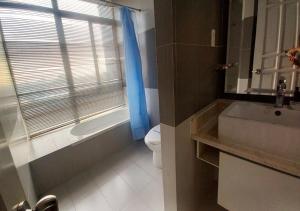 een badkamer met een wastafel, een toilet en een raam bij Khai Hoan Apartment Hotel in Ho Chi Minh-stad