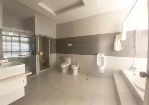 a bathroom with two toilets and a sink and a tub at Khai Hoan Apartment Hotel in Ho Chi Minh City