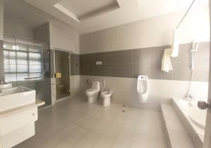 een badkamer met 2 toiletten, een wastafel en een bad bij Khai Hoan Apartment Hotel in Ho Chi Minh-stad