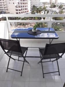 Studio Ponderosa في بلايا ذي لاس أميريكاس: طاولة زرقاء وكرسيين على شرفة