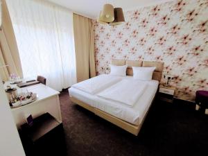 a bedroom with a white bed and a floral wall at Les Nations in Berlin