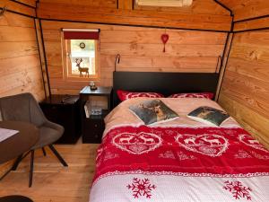 Hoogte Huisje Tirol في Swalmen: غرفة نوم بسرير في كابينة خشبية