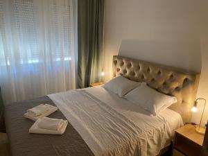 een slaapkamer met een groot bed en 2 handdoeken bij Solaris Apartments in Budva