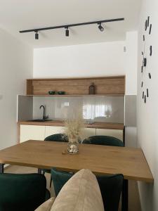 a dining room with a wooden table and green chairs at Solaris Apartments in Budva