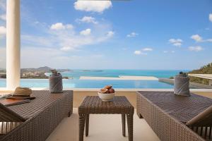 蘇梅島的住宿－Villa The Wave，阳台设有两张桌子,享有海景。