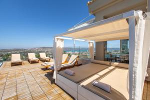 - un balcon avec des chaises et des tables dans une maison dans l'établissement Villa Kedria with a panoramic ocean view, à Souda