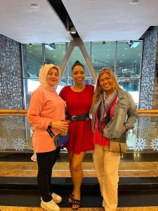three women posing for a picture in a building at Woman ONLY-AnaRuby Backpackers-Mashreq Metro Station in Dubai
