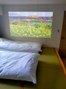 a bedroom with a large painting on the wall at Hostel Belle Via Tokyo in Tokyo