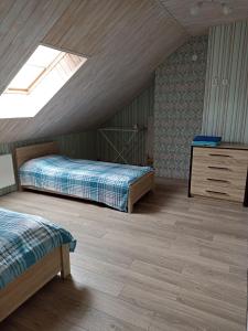 a attic bedroom with two beds and a skylight at Sweet Apartment in Truskavets
