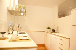 uma cozinha com armários brancos e uma bancada em Apartamento Carmen II em Ferrol