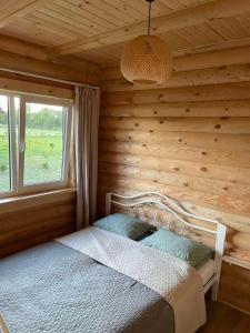 a bedroom with a bed in a wooden room at Vasaras Sapnis in Nida