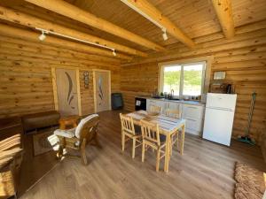 a kitchen and dining room of a log cabin at Vasaras Sapnis in Nida +24 photos