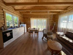 a kitchen and living room in a log cabin at Vasaras Sapnis in Nida