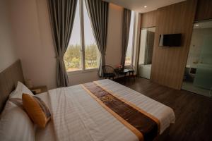 a hotel room with a bed and a large window at LÊ ĐOÀN HOTEL in Rach Gia