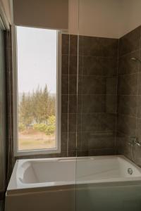 a bathroom with a bath tub and a window at LÊ ĐOÀN HOTEL in Rạch Giá