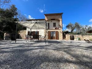 een huis met een tafel en stoelen ervoor bij Villetta Toscana - Montepulciano in Montepulciano