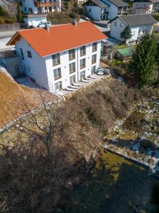 eine Luftansicht eines weißen Gebäudes mit orangefarbenem Dach in der Unterkunft Ferienhäuser Buchenweg in Bodenmais