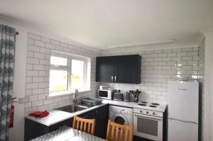 a kitchen with a sink and a refrigerator at F60 Atlantic View, Riviere Towans in Hayle +11 photos