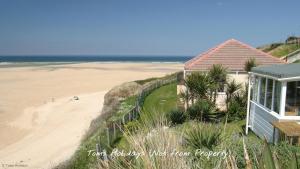 a house on the beach next to a sandy beach at F60 Atlantic View, Riviere Towans in Hayle