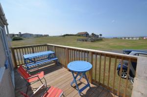 a deck with a blue table and chairs on it at F62 Near Sea, Riviere Towans in Hayle