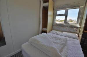 een kleine slaapkamer met een bed en een raam bij F65 Glenette, Riviere Towans in Hayle