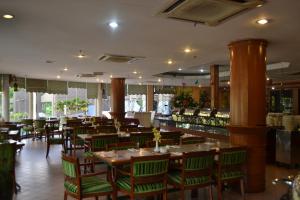 un restaurante con mesas y sillas y un bar en De Rhu Beach Resort, en Kuantan
