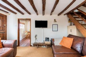 een woonkamer met een bank en een flatscreen-tv bij Annex to Berry Cottage 2 Bedroom Cottage in Bramfield