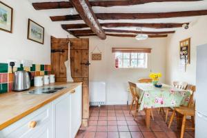 een keuken met een tafel en een eetkamer bij Annex to Berry Cottage 2 Bedroom Cottage in Bramfield