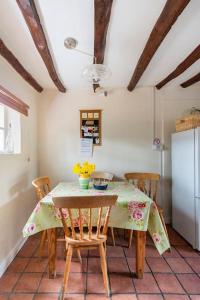 een keuken met een tafel met stoelen en een koelkast bij Annex to Berry Cottage 2 Bedroom Cottage in Bramfield