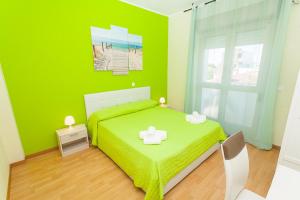 una camera verde con un letto e una finestra di Hotel Romantik a Lignano Sabbiadoro