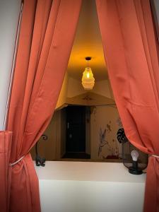 a mirror in a room with red curtains at Gîte les jasmins centre historique Saint-Astier in Saint-Astier