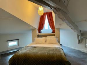 a bedroom with a large bed with a window at Gîte les jasmins centre historique Saint-Astier in Saint-Astier