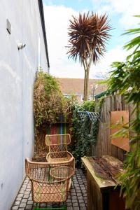 a patio with a bench and a palm tree at The Southwark Wonder - Charming 1BDR Flat with Patio in London