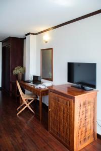 a room with a desk with a flat screen tv at Lao Orchid Hotel in Vientiane