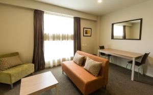 a living room filled with furniture and a couch at Ramada Suites by Wyndham Christchurch City in Christchurch