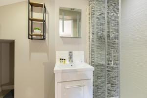 a white bathroom with a sink and a glass shower at Elliot Oliver - 2 Bedroom Garden Apartment With Parking in Cheltenham