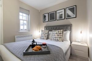 um quarto com uma cama com uma bandeja de comida em Elliot Oliver - 2 Bedroom Garden Apartment With Parking em Cheltenham