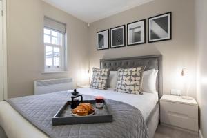 チェルトナムにあるElliot Oliver - 2 Bedroom Garden Apartment With Parkingのベッドルーム1室(ベッド1台、食料品のトレイ付)