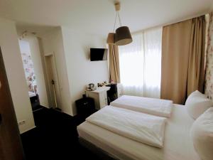 um quarto com uma cama branca e uma janela em Les Nations em Berlim