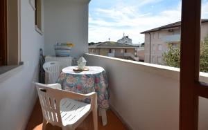 a balcony with a table and two chairs and a window at Appartamenti Cocai, Acquaverde in Bibione
